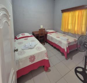 a room with two beds and a table with a fan at Sol in San Benito