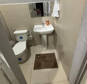 a small bathroom with a toilet and a sink at Sol in San Benito