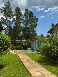 a swimming pool in a yard with grass and trees at Casa ByJ en El Paso in Paso de la Patria