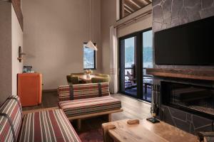 a living room with a fireplace and a television at Ceylan Splend'or Uludag, Autograph Collection in Uludar