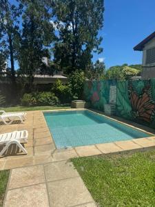a swimming pool in a yard with two chairs next to it at Casa ByJ en El Paso in Paso de la Patria