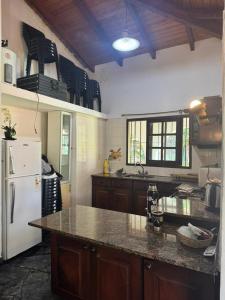 a kitchen with a white refrigerator and a counter top at Casa ByJ en El Paso in Paso de la Patria