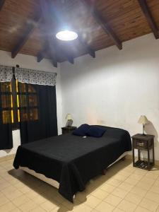 a bedroom with a black bed and two night stands at Casa ByJ en El Paso in Paso de la Patria +19 photos