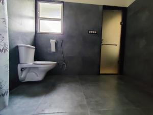 a bathroom with a toilet and a window and a door at Chitrangan The Homestay of Udaipur in Udaipur