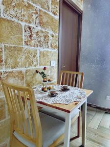 a dining room table with two chairs and a stone wall at B&B Zio Cici in Minervino di Lecce