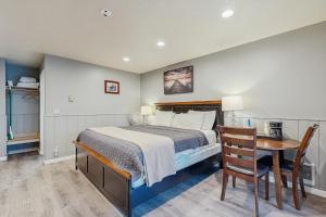 a bedroom with a bed and a table with a chair at Sea Treasures Inn #207 in Rockaway Beach