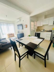 a living room with a table and chairs and a kitchen at Acapulco Vibes - Departamento con Alberca Cerca de Punta Diamante in Acapulco