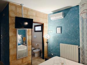 a bathroom with a blue wall with a toilet at B&B Zio Cici in Minervino di Lecce +46 photos