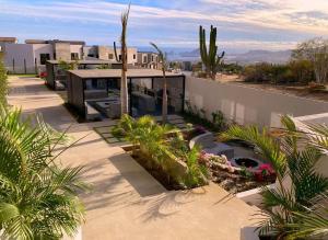 a house with palm trees and a building at Marea Sabina Luxury Ocean View & Amenities in Cabo San Lucas
