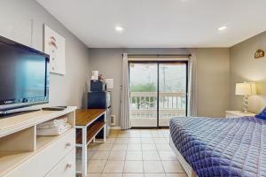 a bedroom with a bed and a flat screen tv at Sea Treasures Inn #208 in Rockaway Beach
