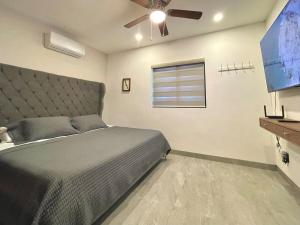 a bedroom with a bed and a flat screen tv at Marea Sabina Luxury Ocean View & Amenities in Cabo San Lucas