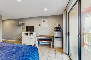 a bedroom with a bed and a desk and a refrigerator at Sea Treasures Inn #208 in Rockaway Beach +15 photos