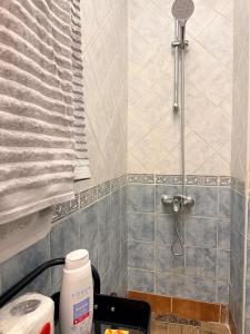 a bathroom with a shower with a sink and a bottle of soap at Chic studio with balcony, quiet & bright in Tétouan +31 photos