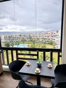 a table and chairs on a balcony with a view at Chic studio with balcony, quiet & bright in Tétouan