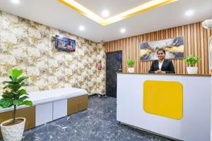 a woman standing at a reception desk in a room at Top Comfort in Kolkata