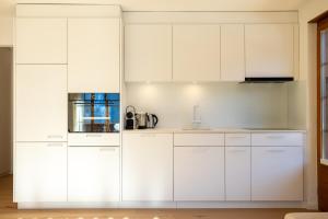a white kitchen with white cabinets at Chalet Valentina in Chateau-d'Oex