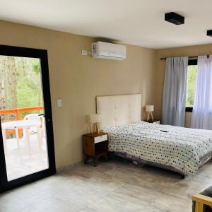 a bedroom with a bed and a sliding glass door at Bosque Libertad Loft in Mar Azul