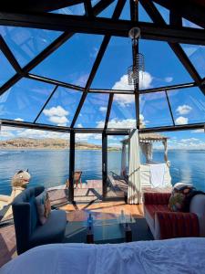 a living room with a view of the water at Uros Lake Titicaca Lodge in Puno +34 photos