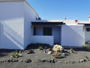 a white house with plants in front of it at Studio Paraíso - Casa Paraíso Playa Blanca in Playa Blanca