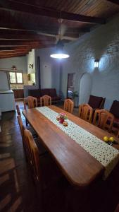 a large wooden table in a room with chairs at Casa Refugio in Paso de la Patria