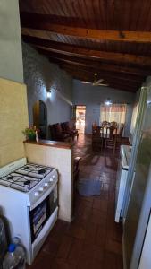 a kitchen with a stove and a living room at Casa Refugio in Paso de la Patria