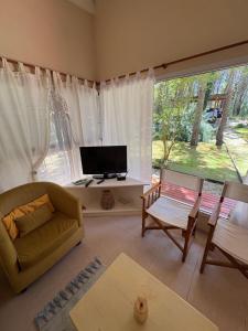 a living room with a couch and a tv at Casa Libertad in Mar de las Pampas
