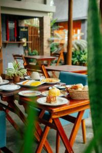 ein Holztisch mit Tellern voller Essen darauf in der Unterkunft Jimbaran Pousada & Bistrot in Maragogi + 25 Fotos