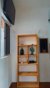 a wooden book shelf in a room with a tv at BELL MAR CHALÉs 03 in Luis Correia