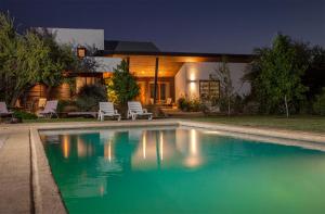 a swimming pool in front of a house at night at Callihue Lodge in Santa Cruz