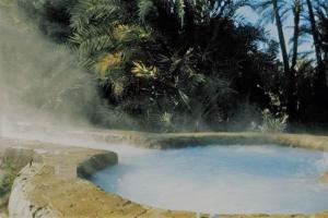 a hot spring with a pool of blue water at Energy camp in Bawati