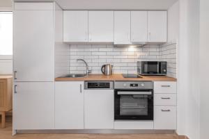 a white kitchen with white cabinets and a sink at Rhodes center Santa Mari in Rhodes Town