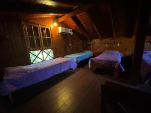 a room with three beds and a window at Cabaña UNO Refugio in Paso de la Patria