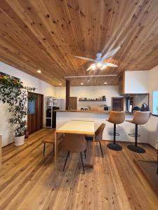 an open kitchen and dining room with a wooden ceiling at HAPPY MAGIC guesthouse in Tateyama