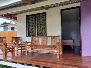 a patio with two benches and a room with wine bottles at Pamilacan Vacay in Baclayon