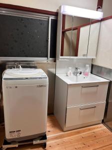 a small white bathroom with a sink and a mirror at HAPPY MAGIC guesthouse in Tateyama +34 photos