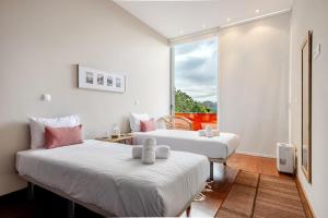 two beds in a room with a window at Keam House in Santana