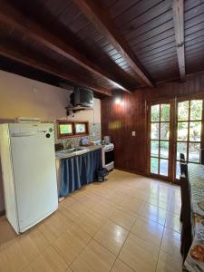 a kitchen with a white refrigerator in a room at Cabaña DOS Refugio in Paso de la Patria