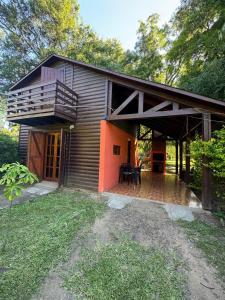 a house with a deck and a balcony at Cabaña DOS Refugio in Paso de la Patria