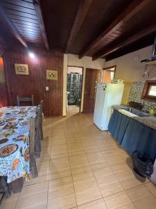 a kitchen with a table and a white refrigerator at Cabaña DOS Refugio in Paso de la Patria +1 photo