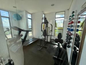 a fitness room with a gym with machines and windows at Flat Jardins Madalena in Recife