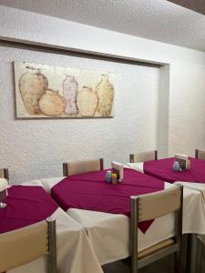 ein Esszimmer mit zwei Tischen mit lila Tischdecken in der Unterkunft Hotel Universo in Guadalajara