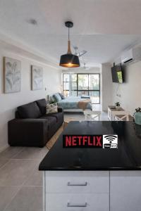 a kitchen and living room with a netflix sign on a counter at La Plage Cabane in Eimeo