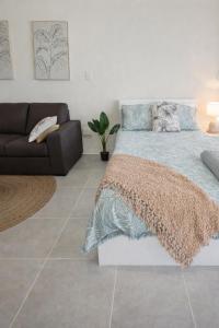 a bedroom with a bed and a couch at La Plage Cabane in Eimeo