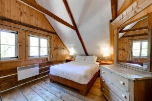 a bedroom with a bed and two windows at Maison Bilodeau Ethier - 5 chambres - 13 personnes in Saint-Férréol-les-Neiges +17 photos