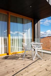 a white table and a chair on a balcony at Foz Côa Story House in Vila Nova de Foz Coa