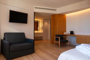 a hotel room with a bed and a chair and a desk at Foz Côa Story House in Vila Nova de Foz Coa