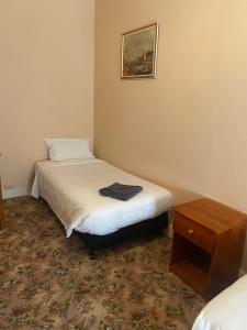 a small bedroom with two beds and a table at Commercial Hotel Camperdown in Camperdown