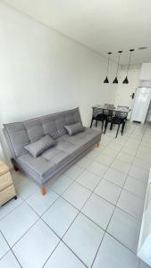 a living room with a couch on a tiled floor at Flat Jardins Madalena in Recife