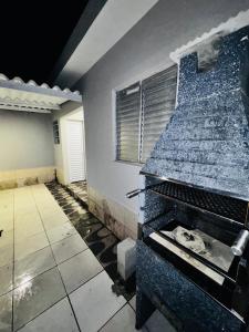 an empty room with a stone fireplace in a house at Casa de praia in Mongaguá