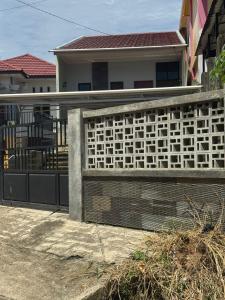 a fence in front of a house at d'house toraja in Rantepao +2 photos